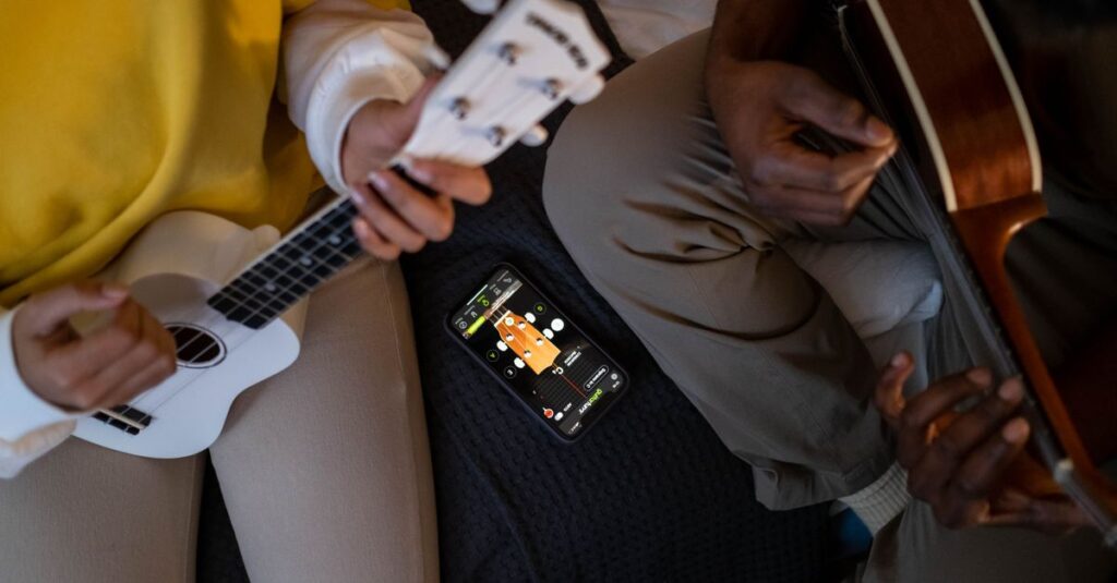 スマホアプリのチューナーに苦戦する初心者ギタリストの様子。